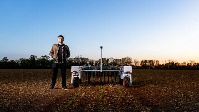 مهندس زراعي يقف بجوار آلة زراعية في المزرعة